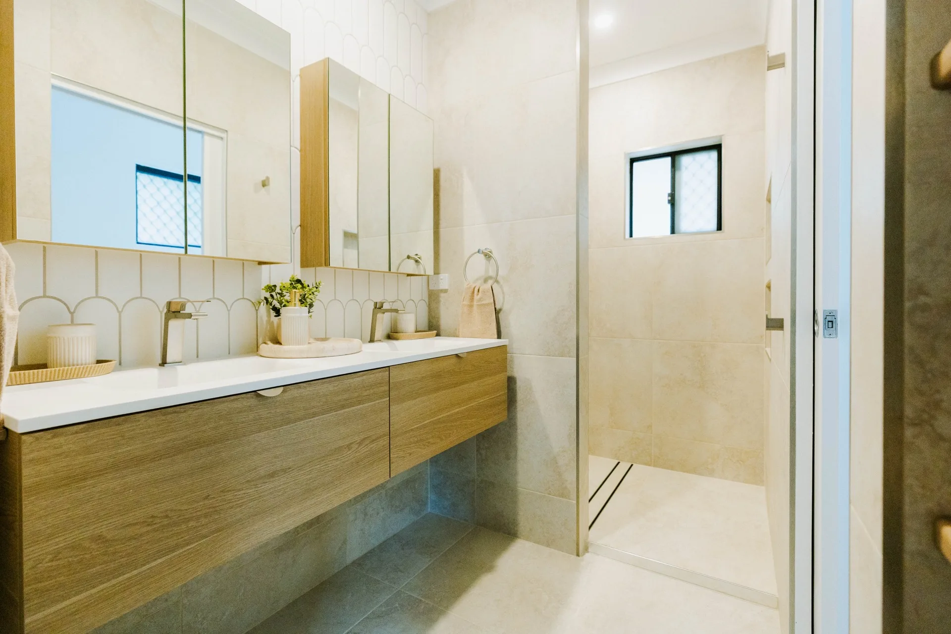 Completed bathroom renovation with double vanity, walk-in shower and scallop tile feature wall — Legacy Building & Construction Townsville