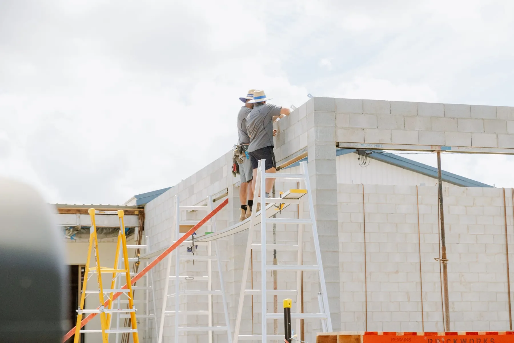 Legacy crew laying the top course of the block wall at Life Church Ingham, ready for the bond beam pour