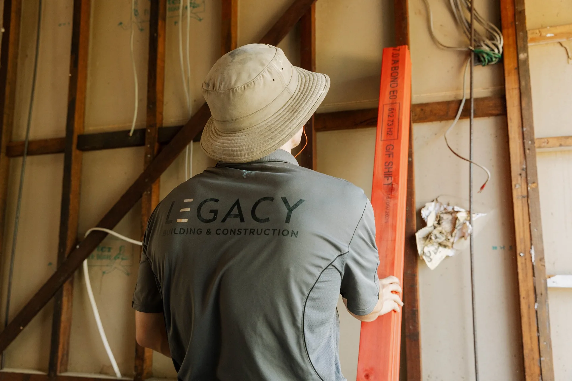 Legacy Building & Construction team member inspecting interior wall framing on site