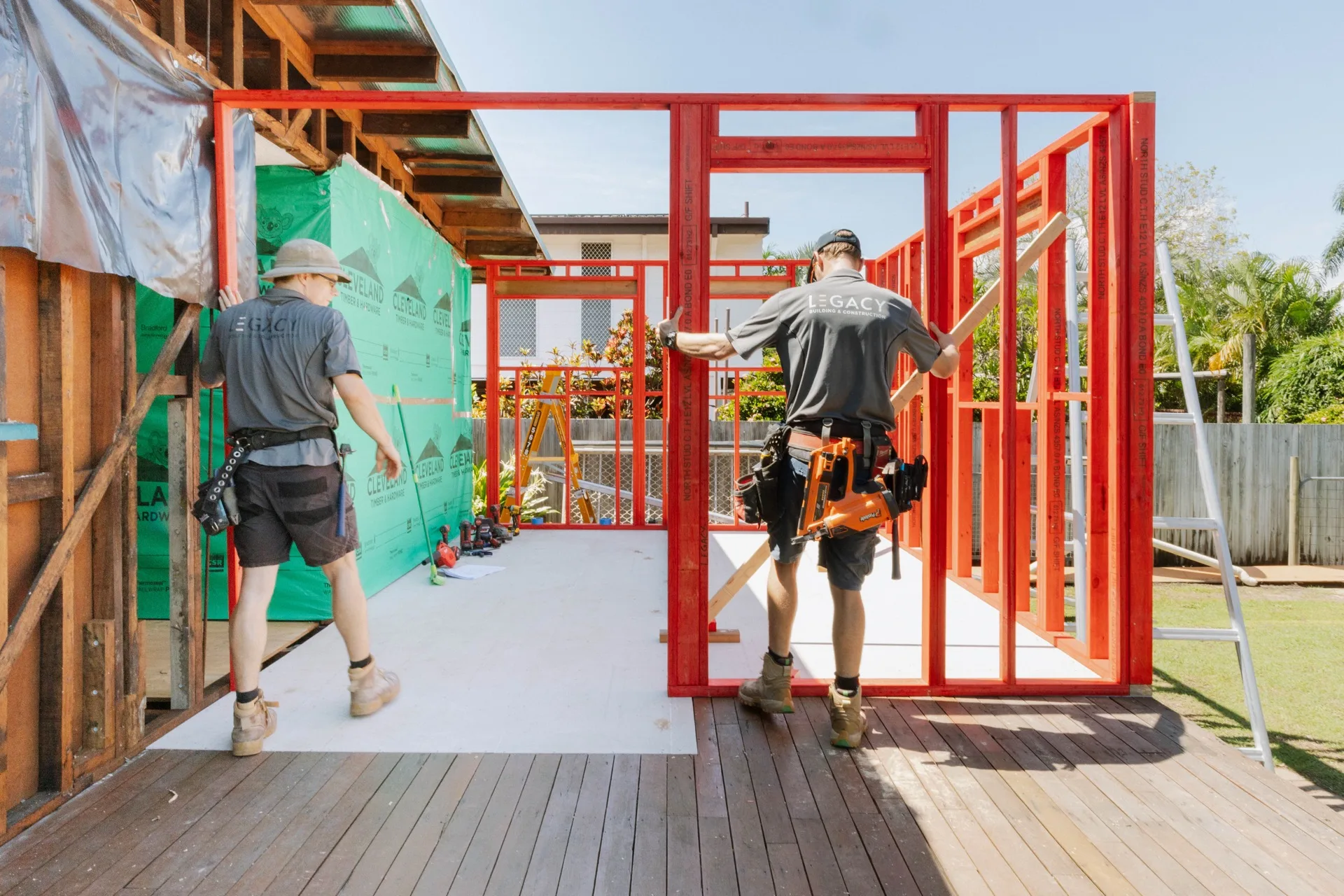 Two Legacy builders working inside the new steel frame extension on a Townsville Queenslander renovation