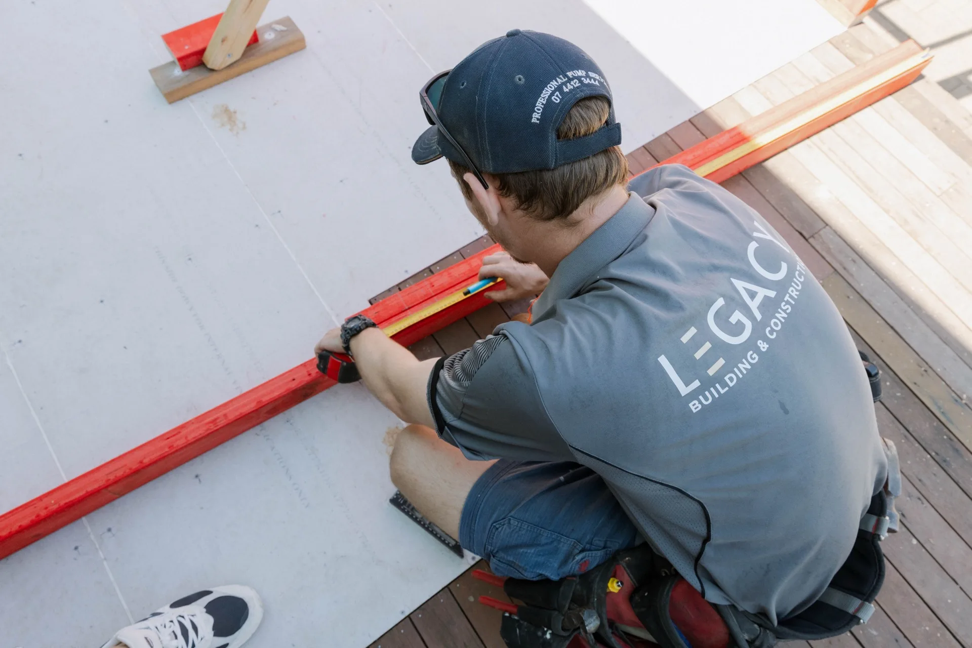 Legacy tradesman levelling a timber deck on site — Townsville North Queensland