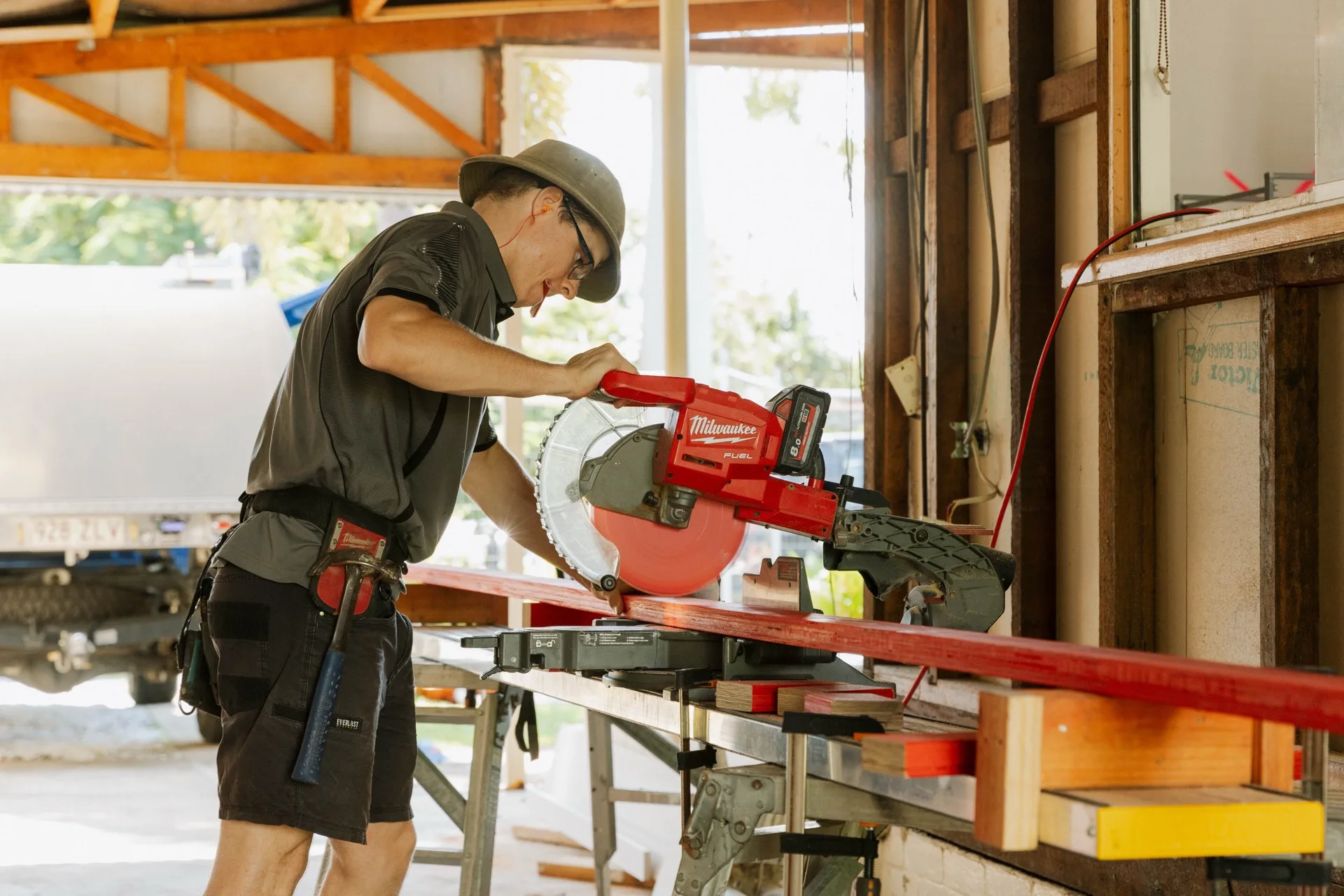 Legacy builder cutting timber on a mitre saw during the renovation