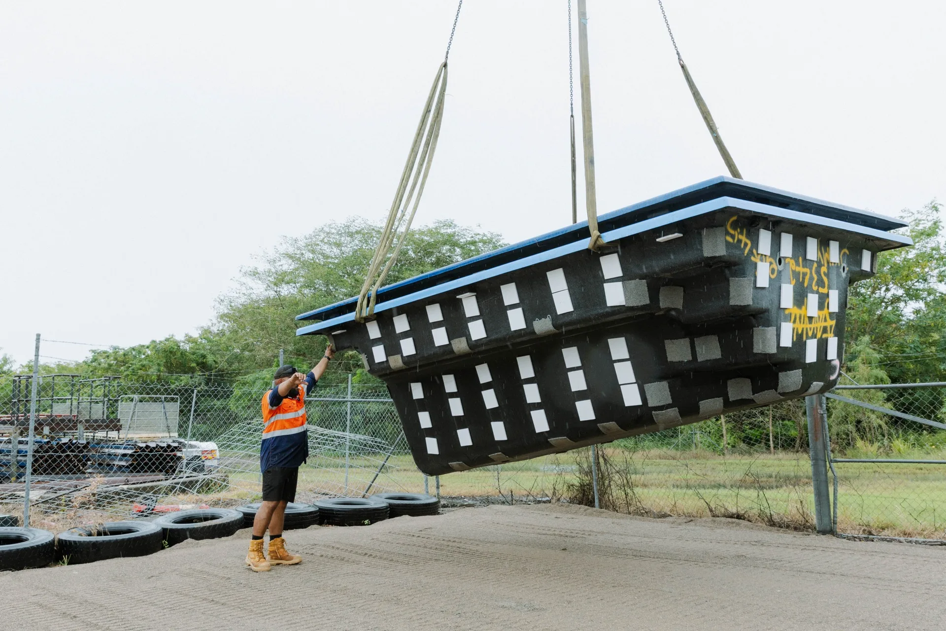 Legacy pool install — fibreglass pool shell being craned into position
